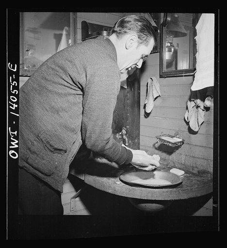 Freight train operaions on the Chicago and Northwestern Railroad between Chicago and Clinton, Iowa. Conductor Wolfsmith washing up in the caboose as the train nears Clinton