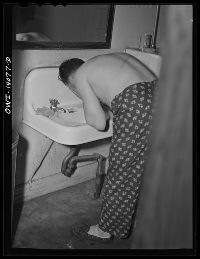 Gibson, Indiana. All the facilities of the railroad YMCA (Young Men's Christian Association) including the washroom, are in use at all hours of the day and night because of the 'round the clock work of railroad men. This brakeman is washing up before going to sleep at 4 p.m. He will go to work at mi