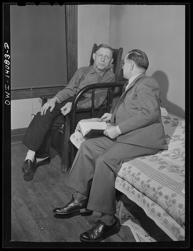 Untitled photo, possibly related to: Gibson, Indiana. Mr. Rusine, manager of the railroad YMCA (Young Men's Christian Association) for twenty-seven years, paying a call on Mr. Hiram Gilman, engineer on the Michigan Central railroad, in the railroad YMCA