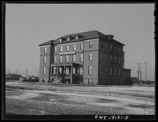 Untitled photo, possibly related to: Gibson, Indiana. The railroad YMCA (Young Men's Christian Association). The stack in the background is from the roundhouse, where the engineers and firemen report for work