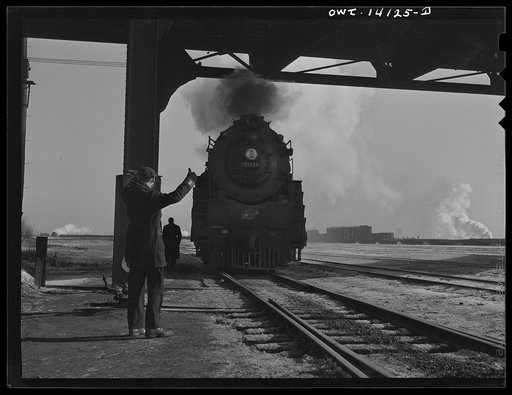 Chicago, Illinois. Conductor giving the engine the OK sign when he arrives after a trip from Clinton, Iowa. The train has been left in the yard and the engine is on its way to the roundhouse. Mr. Wolfsmith, the conductor, can now go home