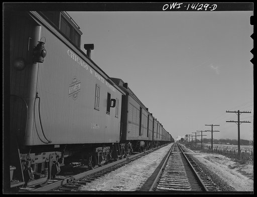 Untitled photo, possibly related to: The Chicago and Northestern Railroad freight train stops before entering the main line to let a passenger train go by