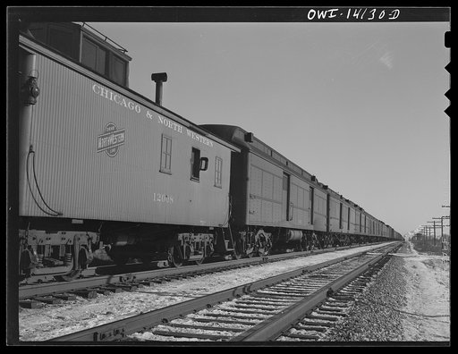 The Chicago and Northestern Railroad freight train stops before entering the main line to let a passenger train go by
