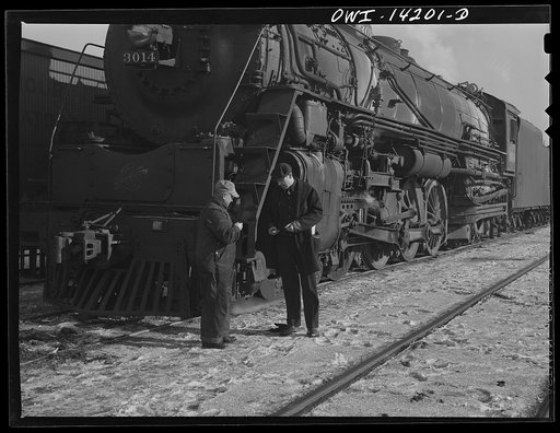 Chicago, Illinois. Engineer and conductor compare time before pulling out a Chicago and Northwestern Railroad freight yard for Clinton, Iowa