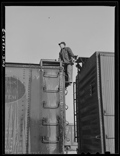 Untitled photo, possibly related to: Rear brakeman inspects train and releases all handbrakes before train pulls out of Proviso yard for Clinton, Iowa (on a trip aboard a Chicago and Northwestern Railroad (C&NWRR) freight train)