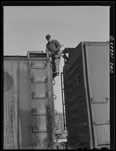 Rear brakeman inspects train and releases all handbrakes before train pulls out of Proviso yard for Clinton, Iowa (on a trip aboard a Chicago and Northwestern Railroad (C&NWRR) freight train)