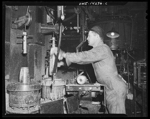 Detroit, Michigan. Steps in the manufacture of casings for 105 mm. shells in the Budd wheel plant. First operation of the finishing machine: threading the nose of the shell