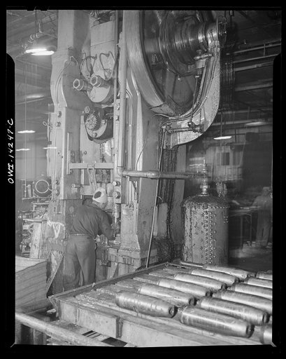 Detroit, Michigan. Steps in the manufacture of casings for 105 mm. shells in the Budd wheel plant. Huge machines used to cold nose rough turned shells