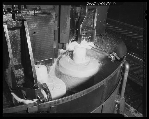 Detroit, Michigan. Steps in the manufacture of casings for 105 mm. shells in the Budd wheel plant. Lubricating fluid pouring on the base end of a shell which is being finished