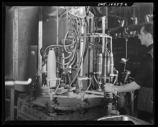 Detroit, Michigan. Steps in the manufacture of casings for 105 mm. shells in the Budd wheel plant. Painting a shell inside and out by means of a spray