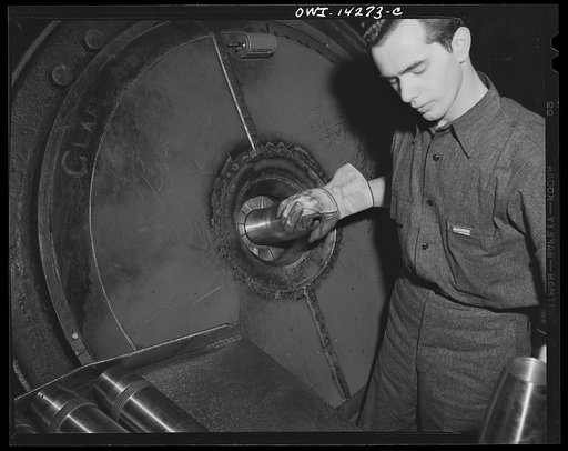 Detroit, Michigan. Steps in the maufacture of casings for 105 mm. shells in the Budd wheel plant. Applying rotating band by means of grotness shrinker