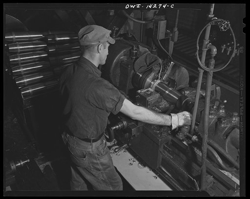 Detroit, Michigan. Steps in the maufacture of casings for 105 mm. shells in the Budd wheel plant. Machining the rotating band on the shell