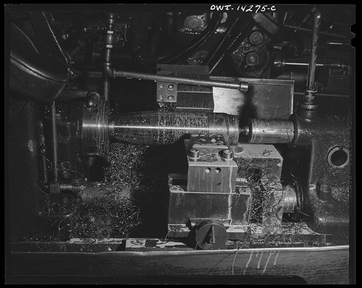 Detroit, Michigan. Steps in the maufacture of casings for 105 mm. shells in the Budd wheel plant. Finishing machine working on the forward part of a shell