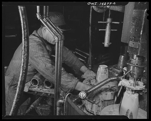 Detroit, Michigan. Steps in the manufacture of casings for 105 mm. shells in the Budd wheel plant. Threading the nose of a shell in the finishing machine