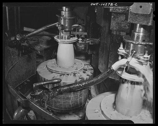 Detroit, Michigan. Steps in the manufacture of casings for 105 mm. shells in the Budd wheel plant. Threading the nose of a shell in the finishing machine with the cutter on the inside of the nose