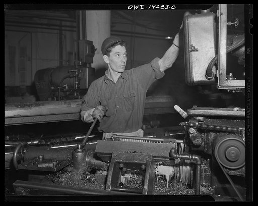Detroit, Michigan. Steps in the manufacture of casings for 105 mm. shells in the Budd wheel plant. Rough turning a shell, showing young machine operator