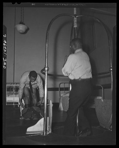 Firehouse station number four. Washington, D.C. A young fireman sleeps in his shirt and socks. When the alarm goes off he steps quickly into his boots that have pants attached complete with suspenders, adjusts them on the run, and slides down the pole to