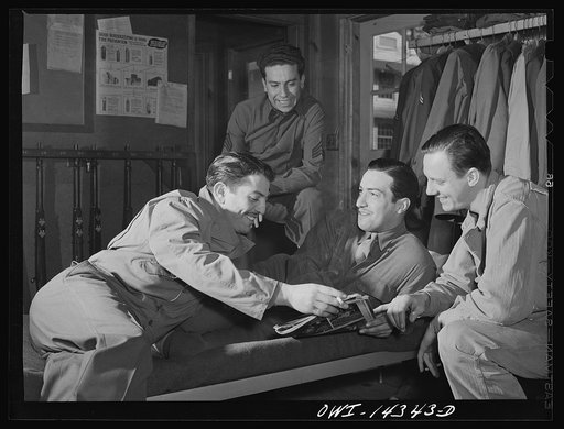 Fort Belvoir, Virginia. Privates Chirico and Dalto and another soldier looking at Collier's magazine in their barracks