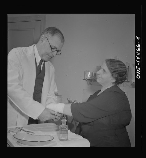 New York, New York. Italian surgeon bandaging a patient's arm
