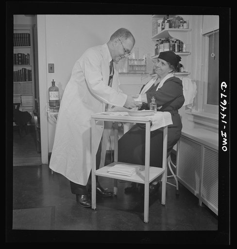 New York, New York. Italian surgeon bandaging a patient's arm