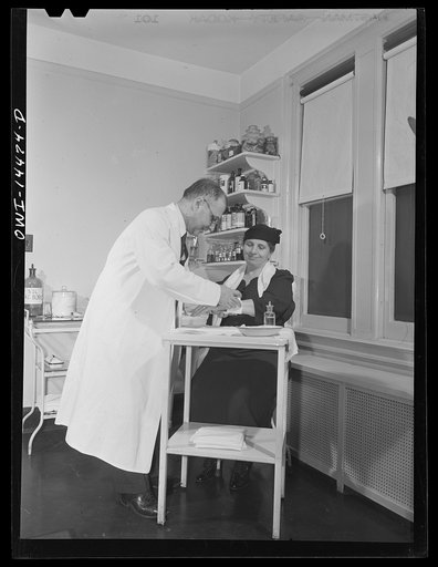 Untitled photo, possibly related to: New York, New York. Italian surgeon bandaging a patient's arm