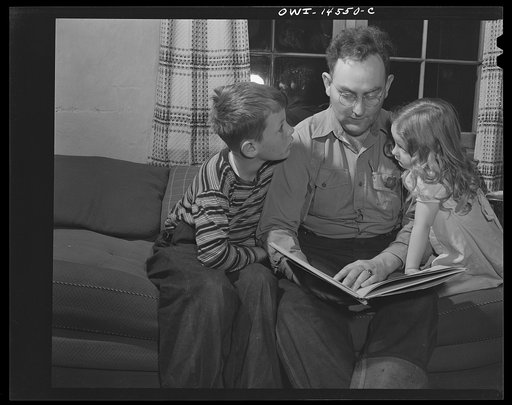 Penasco, New Mexico. U.S. forest ranger reading to his children
