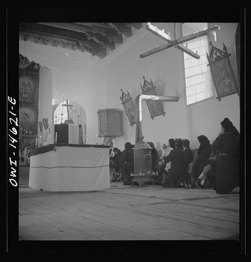 Trampas, New Mexico. Memorial mass at a church which was built in 1700 and is the best-preserved colonial mission in the Southwest. Altar in the center is a symbolic coffin