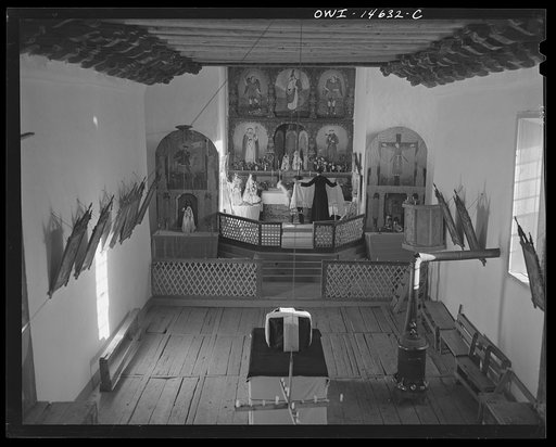 Trampas, New Mexico. Father Cassidy dressing the altar prior to giving a memorial service in a church which was built in 1700 and is the best-preserved colonial mission in the Southwest
