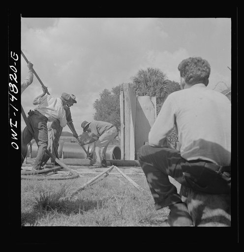 Daytona Beach, Florida. A foreman watching a Negro workman prepare to lay a sewer pipeline