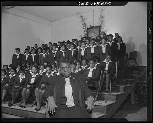 Daytona Beach, Florida. Bethune-Cookman College. Dr. Mary McLeod Bethune bowing her head and listening to a chorus of seventy-three voices sing the Lord's Prayer during Sunday chapel services