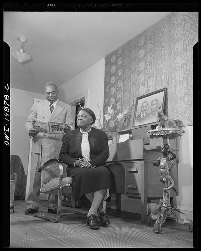 Daytona Beach, Florida. Bethune-Cookman College. Dr. Bethune's son reading an article from the Time magazine to his mother in the family home on the campus