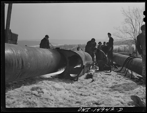Pennsylvania section of the war emergency twenty-four inch pipeline to carry oil from Texas to eastern refineries, completed in July 1943. Making a bend in a section of pipe