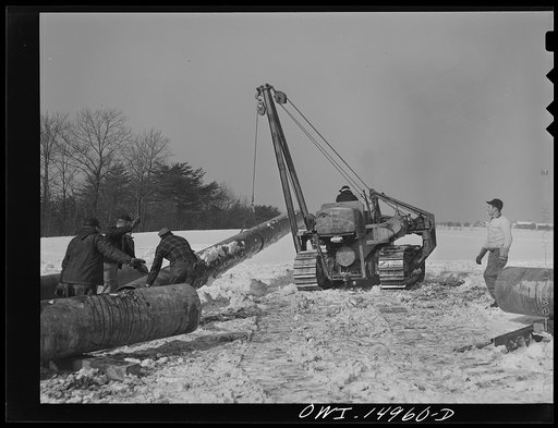 Pennsylvania section of the war emergency twenty-four inch pipeline to carry oil from Texas fields to eastern refineries, completed in July 1943. Hoisting a section of pipe