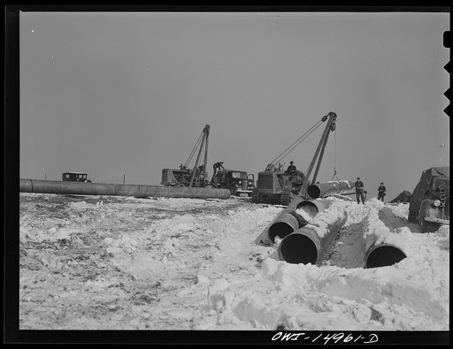 Pennsylvania section of the war emergency twenty-four inch pipeline to carry oil from Texas fields to eastern refineries, completed in July 1943. Hoisting a section of pipe