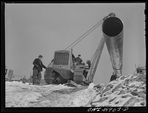 Pennsylvania section of the war emergency twenty-four inch pipeline to carry oil from Texas fields to eastern refineries, completed in July 1943. Hoisting a section of pipe