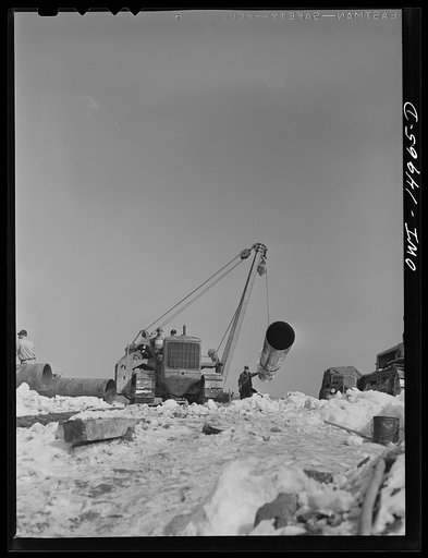 Pennsylvania section of the war emergency twenty-four inch pipeline to carry oil from Texas fields to eastern refineries, completed in July 1943. Hoisting a section of pipe