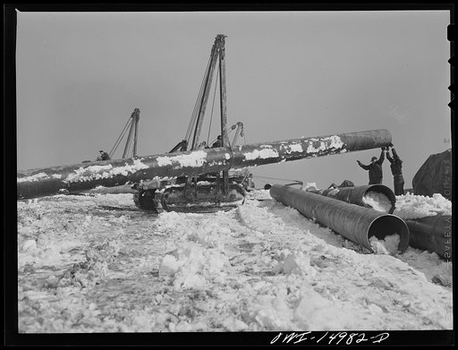 Pennsylvania section of the war emergency twenty-four inch pipeline to carry oil from Texas fields to eastern refineries, completed in July 1943. Hoisting a section of pipe