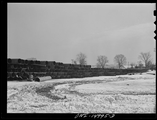Pennsylvania section of the war emergency twenty-four inch pipeline to carry oil from Texas fields to eastern refineries, completed in July 1943. Pipe stacked along the railroad tracks
