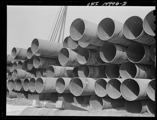 Pennsylvania section of the war emergency twenty-four inch pipeline to carry oil from Texas fields to eastern refineries, completed in July 1943. Pipe stacked along the railroad tracks