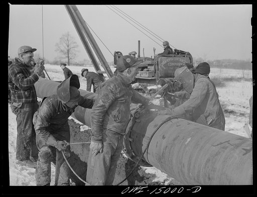 Pennsylvania section of the war emergency twenty-four inch pipeline to carry oil from Texas fields to eastern refineries, completed in July 1943. Tack welding a section of pipe to the main line