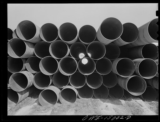 Pennsylvania section of the war emergency twenty-four inch pipeline to carry oil from Texas fields to eastern refineries, completed in July 1943. Pipe stacked along the railroad tracks