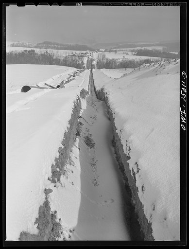 Pennsylvania section of the war emergency twenty-four inch pipeline to carry oil from Texas fields to eastern refineries, completed in July 1943. Ditch and strung pipe cutting through hilly country