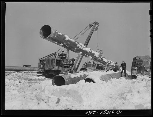 Pennsylvania section of the war emergency twenty-four inch pipeline to carry oil from Texas fields to eastern refineries, completed in July 1943. Hoisting a section of pipe