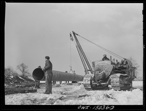 Pennsylvania section of the war emergency twenty-four inch pipeline to carry oil from Texas fields to eastern refineries, completed in July, 1943. Hoisting a section of pipe