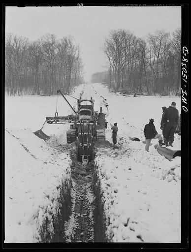 Pennsylvania section of the war emergency twenty-four inch pipeline to carry oil from Texas fields to eastern refineries, completed in July, 1943. Ditching machine going through the woods