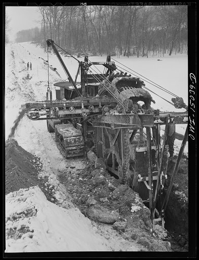 Pennsylvania section of the war emergency twenty-four inch pipeline to carry oil from Texas fields to eastern refineries, completed in July, 1943. Ditching machine going through the woods