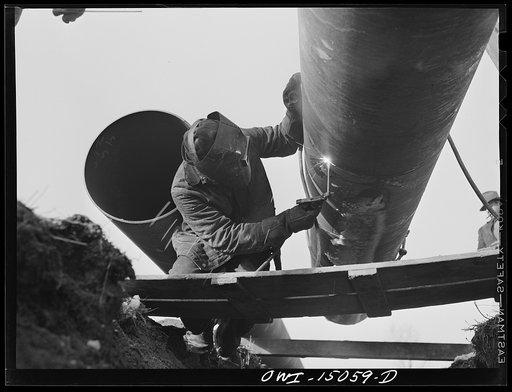 Pennsylvania section of the war emergency twenty-four inch pipeline to carry oil from Texas fields to eastern refineries, completed in July, 1943. Willis Garner tack welding a section of pipe to the main line