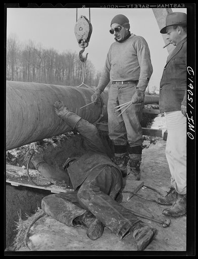 Pennsylvania section of the war emergency twenty-four inch pipeline to carry oil from Texas fields to eastern refineries, completed in July, 1943. Willis Garner tack welding a section of pipe to the main line