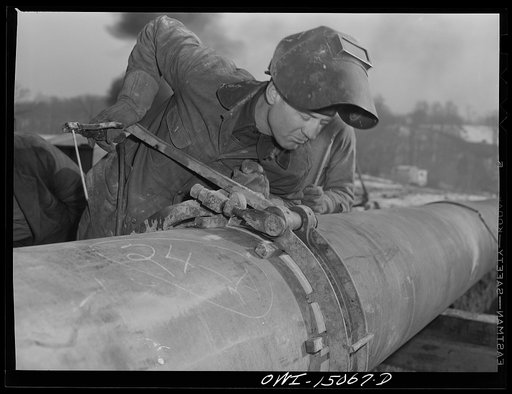 Pennsylvania section of the war emergency twenty-four inch pipeline to carry oil from Texas fields to eastern refineries, completed in July, 1943. Willis Garner about to tack a weld section of pipe