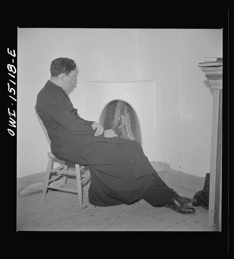 Trampas, New Mexico. Father Cassidy, resident priest of the parish of Penasco, by the fireside